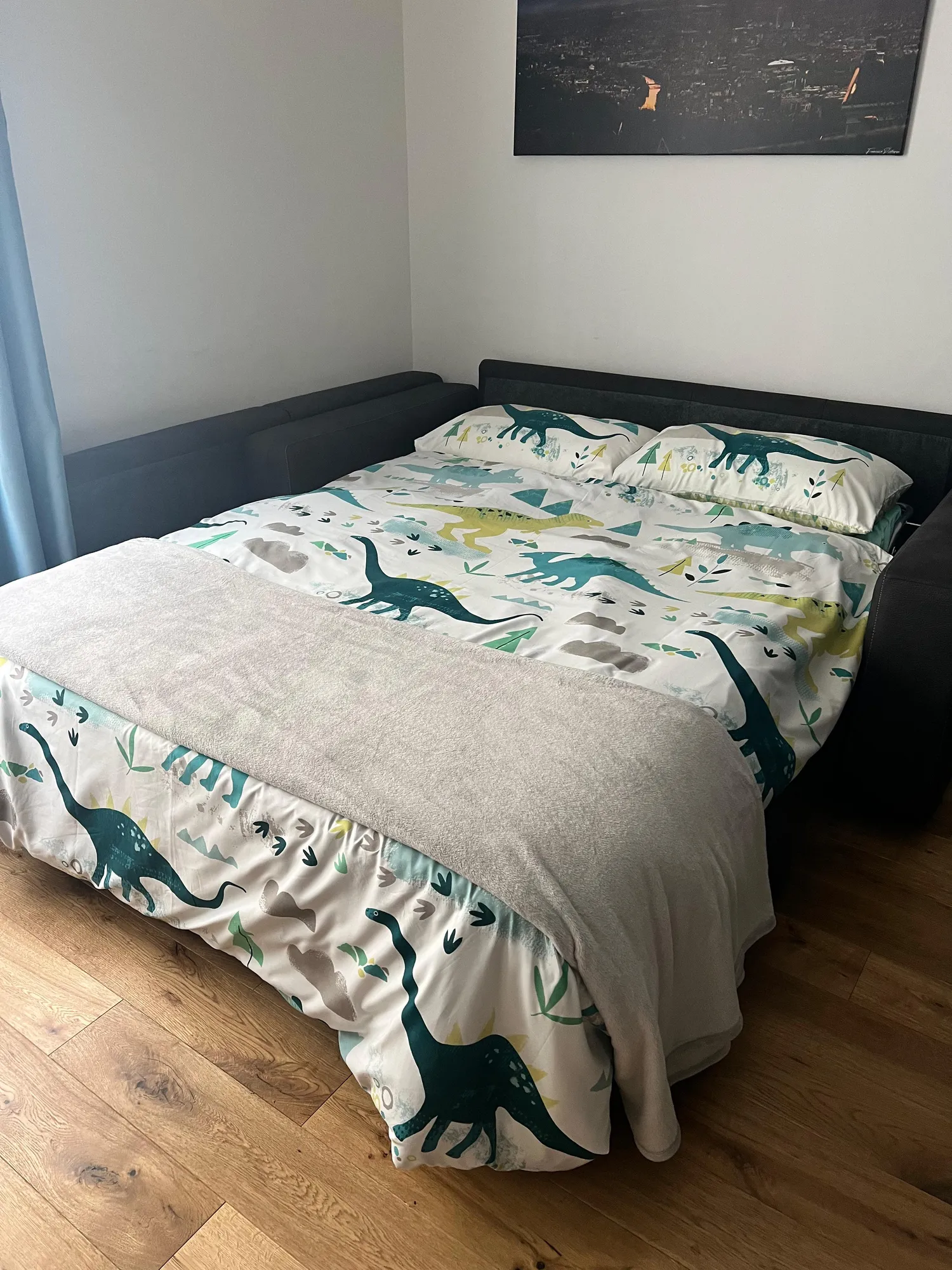Divano letto del Glam Turin Apartment preparato con biancheria a fantasia per bambini e una coperta morbida